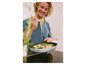 Un homme goûte un plat de pâtes et de légumes dans une poêle.