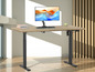 Un bureau en bois avec une hauteur réglable électriquement, un moniteur et un clavier.