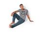 Un homme porte un t-shirt gris avec un imprimé Spiderman et un pantalon de pyjama bleu.