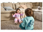 Deux enfants jouent sur un tapis avec un sweat-shirt rose et bleu imprimé.