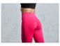 Une femme portant un legging rose et un soutien-gorge de sport noir.