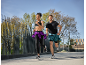 Deux personnes courent en tenue de sport, avec un coupe-vent noué à la taille.