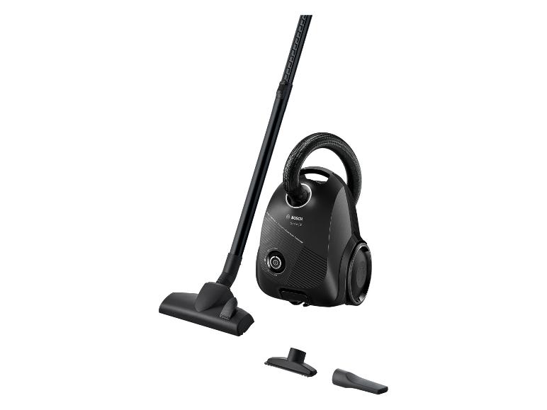 Aspirateur traîneau noir avec tuyau, tube et accessoires sur fond blanc.