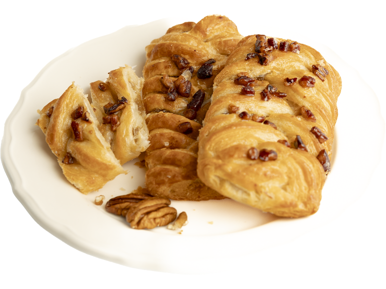 Pâtisseries tressées aux noix de pécan sur une assiette blanche, l'une d'elles coupée en morceaux.