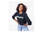 Femme en sweat-shirt bleu marine avec « BONJOUR » et jean