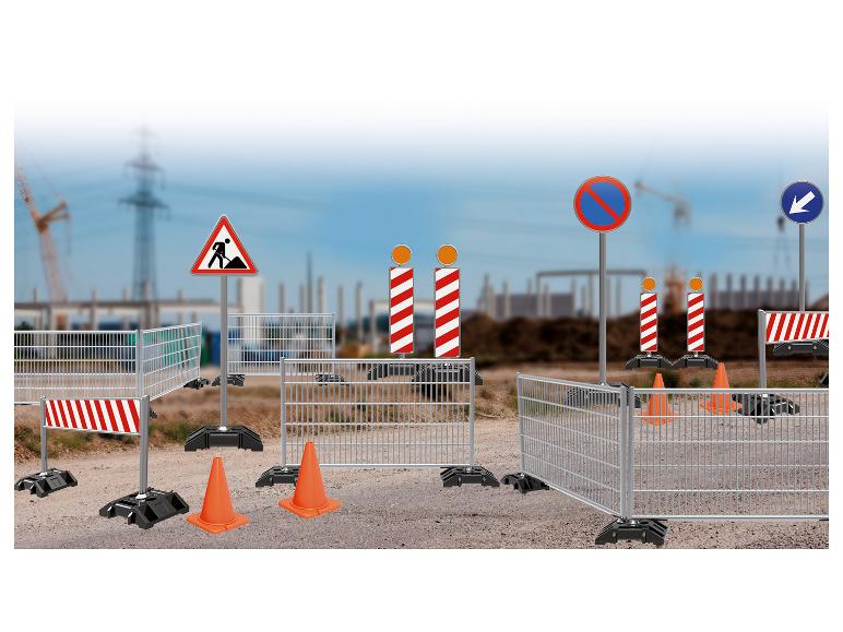 Ensemble de construction avec clôtures, panneaux et cônes.