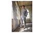 Homme en sweat-shirt gris et pantalon de jogging New Balance dans un bâtiment abandonné.