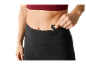Une femme rangeant une clé dans la poche de son legging de sport.