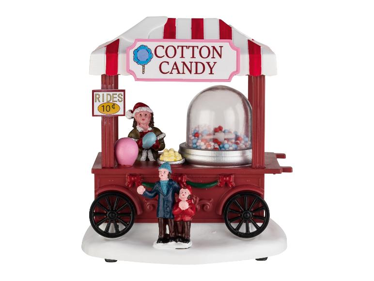 Un chariot festif de barbe à papa avec des figurines, un panneau 'Rides 10¢' et un distributeur de bonbons.