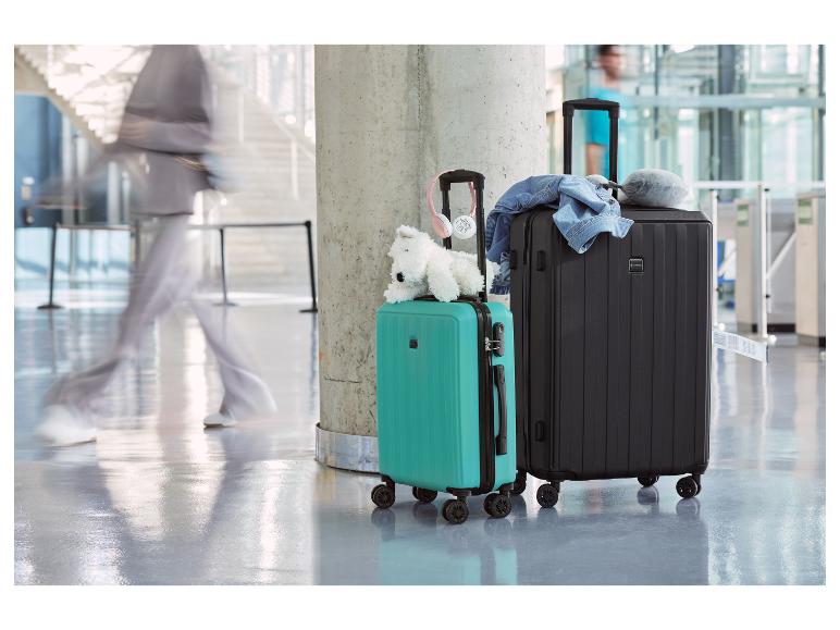 Deux valises, une noire et une turquoise, dans un aéroport.