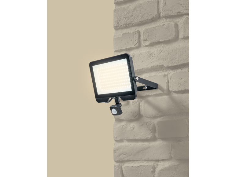 Projecteur extérieur LED avec détecteur de mouvement monté sur un mur en briques