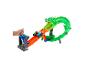 Une main d'enfant lance deux monster trucks sur une piste orange vers la gueule d'un dragon vert.