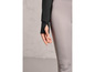 Gros plan sur un sweat-shirt noir avec des trous pour les pouces et un legging gris.