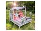 Deux petites filles se détendent sur une banquette de jardin en bois avec des coussins étoilés.