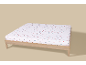 Drap-housse blanc avec de petits cadeaux de Noël colorés et des cannes à sucre sur un cadre en bois.