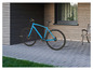 Un vélo Easymaxx bleu pour adultes garé devant une maison.