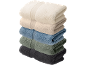 Une pile de cinq serviettes pliées de différentes couleurs sur fond noir.