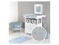 Commode à langer blanche avec matelas à langer bleu clair, fauteuil bleu clair et tapis assorti dans une chambre d'enfant.