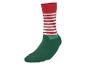 Une chaussette de lutin de Noël rayée rouge et blanche avec un pied vert.