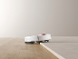Aspirateur robot blanc franchissant un seuil entre deux sols différents