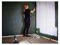 Femme peignant un mur au rouleau, éclairée par une lampe de travail LIVARNO®.