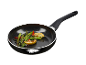 Une poêle noire avec des asperges sautées, du citron et du piment.