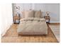 Parure de lit beige clair sur un lit dans une chambre moderne.