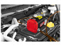 Une pompe de vidange d'huile Ultimate Speed ​​rouge avec un tuyau dans le compartiment moteur d'une voiture.