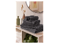 Une pile de serviettes de bain gris foncé sur une étagère de salle de bain.