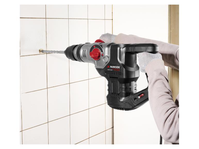 Personne perçant un trou dans un carreau blanc avec un marteau perforateur Parkside Performance SDS Max.