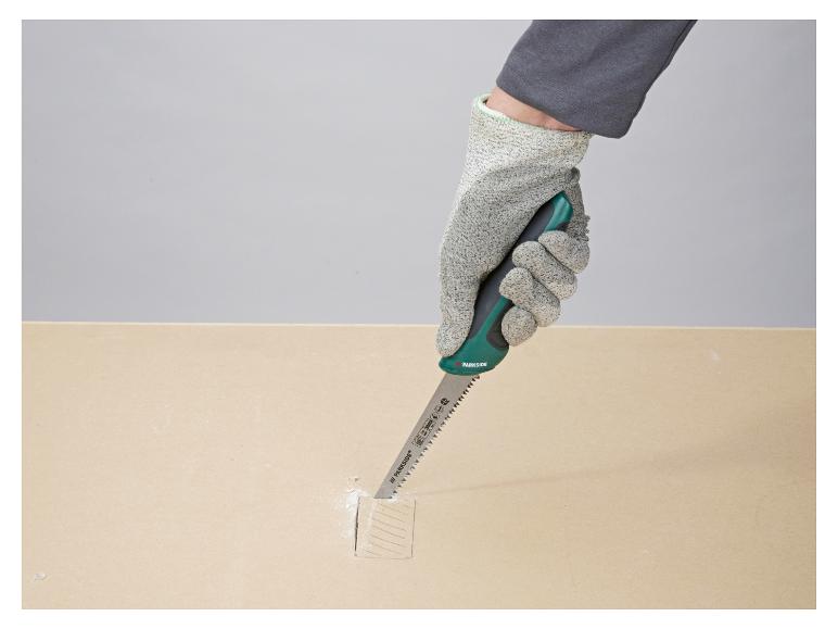 Main gantée coupant du bois avec une scie à main Parkside