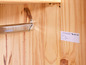 Une tringle à vêtements chromée dans une armoire en bois Inter Link.