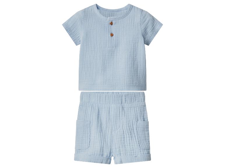 Ensemble bébé bleu avec chemise à manches courtes et short à poches.