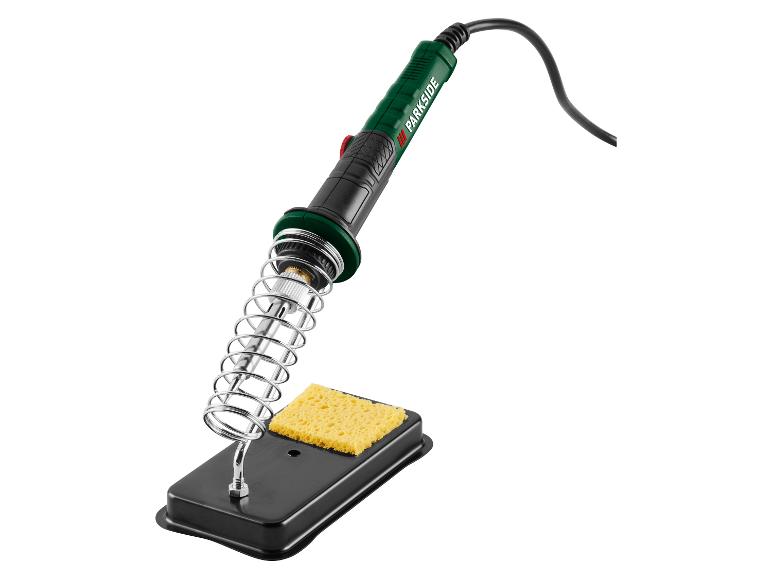Un fer à souder vert et noir avec un support métallique et une éponge jaune.