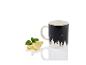 Une tasse noire avec un imprimé de forêt, des tranches de citron et des feuilles de menthe.