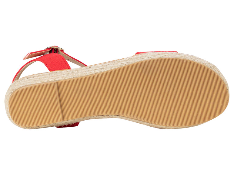 La semelle d'une sandale espadrille rouge avec une boucle