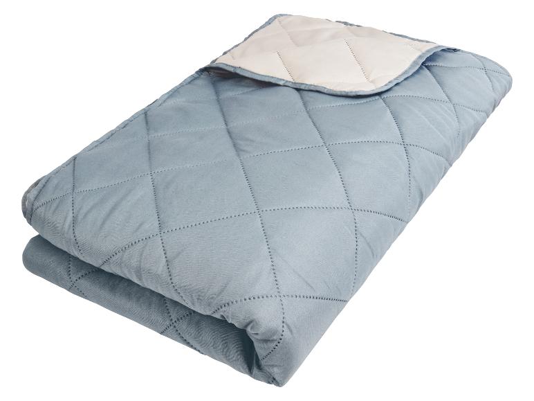 Couette matelassée bleu clair, douce et confortable.