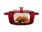 Cocotte en fonte rouge avec un poulet rôti à l'intérieur.