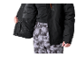 Personne en veste de ski noire et pantalon de ski à motifs.