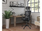 Une chaise de bureau en mesh noire avec appui-tête dans un bureau moderne.