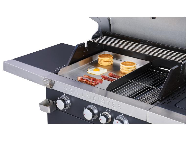 Barbecue avec plancha où sont cuits des pancakes, des œufs et du bacon.