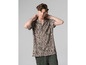 Homme portant une chemise beige à motif noir.