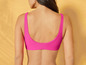 Une femme portant un haut de bikini rose.