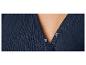 Détail d'une robe bleu marine à plis fins, fermeture boutonnée.