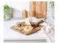 Une planche à découper en bois Russell Hobbs avec du fromage, des craquelins et des raisins.