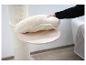 Main plaçant un coussin doux et moelleux sur une plateforme en bois d'un arbre à chat.