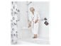 Une femme âgée en peignoir utilise un tabouret de douche pliable dans une salle de bain moderne.