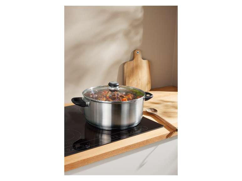Une casserole en acier inoxydable avec de la nourriture qui cuit sur une plaque à induction.