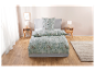 Parure de lit fleurie vert clair dans une chambre moderne.