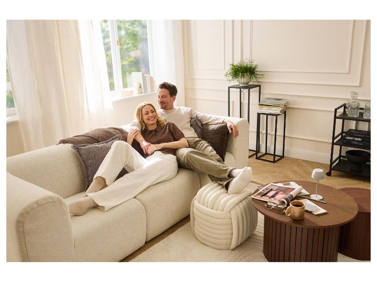 Couple se détendant sur le canapé, avec LIVARNO® LED-Akku-Tischleuchte sur la table basse.